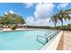 A well-maintained pool featuring metal handrails, lounge chairs, and meticulous landscaping with palm trees at 1294 Riverscape St # D, Bradenton, FL 34208