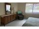 Bright bedroom with dresser, chair, and large window with horizontal blinds at 1330 Glen Oaks E Dr # 276D, Sarasota, FL 34232