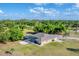 Aerial view of home, screened pool, set among lush green surroundings offering privacy at 1668 Tropicaire Blvd, North Port, FL 34286