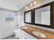 Bathroom showcasing double sinks, vanity mirrors, and shower-tub combo at 1668 Tropicaire Blvd, North Port, FL 34286