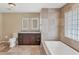 Bathroom featuring double vanity, standalone tub, and natural light from a glass block window at 1668 Tropicaire Blvd, North Port, FL 34286