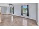 Large bedroom with neutral tile floors, two windows, and a ceiling fan at 1668 Tropicaire Blvd, North Port, FL 34286