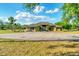 Spacious ranch home boasts tropical landscaping, a circular drive, and striking front door and windows at 1668 Tropicaire Blvd, North Port, FL 34286