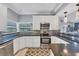 Stylish kitchen with white cabinets, black countertops, and stainless steel appliances at 1668 Tropicaire Blvd, North Port, FL 34286