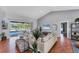 Light-filled living room with vaulted ceiling, wood floors, comfortable seating, and screened lanai access at 1668 Tropicaire Blvd, North Port, FL 34286