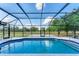 Screened-in pool area with a pristine pool and a view of the spacious backyard and surrounding landscape at 1668 Tropicaire Blvd, North Port, FL 34286