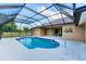 Sparkling pool with screen enclosure, and a view of the house exterior and backyard space at 1668 Tropicaire Blvd, North Port, FL 34286