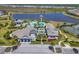 A high-angle view of a stunning community clubhouse with a large pool, tennis courts, and meticulously landscaped grounds at 17675 Azul Dr, Lakewood Ranch, FL 34202