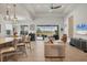 Open-concept living room with modern furnishings, light tile flooring, and sliding glass doors to outdoor living space at 17675 Azul Dr, Lakewood Ranch, FL 34202