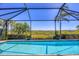 Inviting screened-in pool with a tranquil view and tropical landscaping at 17675 Azul Dr, Lakewood Ranch, FL 34202