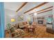 Bright living room with a stone fireplace, tile floors, and exposed wood beams at 2110 Euclid Ter, Sarasota, FL 34239