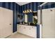 This contemporary bathroom features a glass shower enclosure, a vanity with double sinks, and striped walls at 21221 Wacissa Dr, Venice, FL 34293