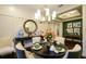 Elegant dining room with a chandelier, large round mirror, and a stylish table set for a meal at 21221 Wacissa Dr, Venice, FL 34293