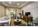 Inviting living room with hardwood floors, tray ceilings, and access to a patio area with a pool at 21221 Wacissa Dr, Venice, FL 34293