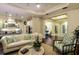 Elegant living room with dark hardwood floors, tray ceilings, and an open layout to the kitchen and foyer at 21221 Wacissa Dr, Venice, FL 34293