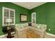 Comfortable living room with green walls, a neutral sectional sofa, bamboo coffee table, and natural light at 21221 Wacissa Dr, Venice, FL 34293