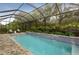 Relaxing screened pool area with a brick deck, two lounge chairs and a built-in spa at 21221 Wacissa Dr, Venice, FL 34293