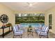 Enclosed outdoor lounge area with views of the pool, water feature, and tropical landscaping at 21221 Wacissa Dr, Venice, FL 34293