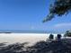 Beach scene with chairs and clear ocean waters at 2340 Canal Dr # G-35, Bradenton, FL 34207