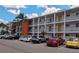 White condo building featuring orange accent with ample parking and tropical landscaping on a sunny day at 2340 Canal Dr # G-35, Bradenton, FL 34207