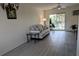 Bright living room features sliding glass doors to a screened patio overlooking tropical trees and new vinyl flooring at 2340 Canal Dr # G-35, Bradenton, FL 34207