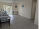 Bright living room features sliding glass doors to a screened patio overlooking tropical trees and new vinyl flooring at 2340 Canal Dr # G-35, Bradenton, FL 34207