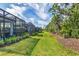 Spacious backyard with manicured lawn, tropical plants, and a row of hedges for privacy at 2628 Sapphire Blue Ln, Bradenton, FL 34211