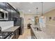 Open kitchen with stainless steel appliances, granite countertops, and black cabinets with an island and kitchen sink at 2628 Sapphire Blue Ln, Bradenton, FL 34211