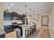 Modern kitchen features granite countertops, stainless steel appliances, dark cabinetry, and a breakfast bar with seating at 2628 Sapphire Blue Ln, Bradenton, FL 34211