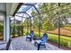 Screened lanai offering views of mature landscaping and a scenic backyard at 2628 Sapphire Blue Ln, Bradenton, FL 34211