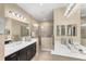 Elegant main bathroom with dual sinks, frameless glass shower, and neutral tile flooring at 2628 Sapphire Blue Ln, Bradenton, FL 34211