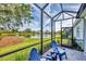 Screened patio with comfortable seating offering serene lake views at 2628 Sapphire Blue Ln, Bradenton, FL 34211