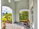 Charming covered patio area with brick floor and views of the landscaped front yard at 2628 Sapphire Blue Ln, Bradenton, FL 34211