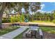 Community playground area with slides, swings, benches, a picnic table, and mature trees at 2628 Sapphire Blue Ln, Bradenton, FL 34211