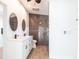 Modern bathroom featuring double sinks, white cabinets, and a shower with decorative tile at 2703 Avenue B, Holmes Beach, FL 34217
