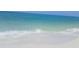 Scenic shot of a pristine beach with clear turquoise water and gentle waves rolling onto the shore at 2703 Avenue B, Holmes Beach, FL 34217