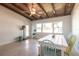 Dining area with a wooden table, vibrant chairs, terrazzo floor, and a ceiling with wood beams at 2703 Avenue B, Holmes Beach, FL 34217