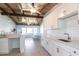Bright, remodeled kitchen with white cabinets, marble countertops, and exposed wood beam ceilings at 2703 Avenue B, Holmes Beach, FL 34217