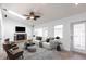 Bright living room with fireplace, ceiling fan, and white sofa near the door and large windows at 2703 Avenue B, Holmes Beach, FL 34217