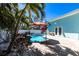 Private in-ground pool surrounded by lush landscaping, an umbrella, and a light blue exterior at 2703 Avenue B, Holmes Beach, FL 34217