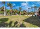 Expansive grassy backyard with mature palm trees, American flag, and a partially fenced perimeter at 280 W Cowles St, Englewood, FL 34223