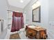 Bathroom with a unique vanity, marble countertop, elegant mirror, and combined shower and tub at 280 W Cowles St, Englewood, FL 34223