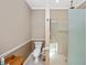 Bright bathroom featuring a toilet, tan paint, and a tiled shower at 280 W Cowles St, Englewood, FL 34223