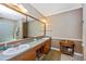 Bathroom featuring a double vanity with wood cabinets and a large mirror at 280 W Cowles St, Englewood, FL 34223