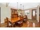 Well-lit dining room featuring hardwood floors, a wooden table with seating, and a charming china cabinet at 280 W Cowles St, Englewood, FL 34223
