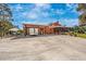 Exterior view of the home showcasing a large parking area, covered parking, and a screened porch at 280 W Cowles St, Englewood, FL 34223