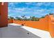 A spacious terrace area with views of palm trees and blue sky, enclosed by an orange stucco wall at 280 W Cowles St, Englewood, FL 34223