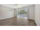 Bright bedroom with wood-look flooring, ceiling fan, and sliding doors to a screened deck at 2926 River Run Way, Bradenton, FL 34208