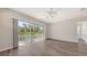Bright bedroom with wood-look flooring, ceiling fan, and sliding doors to a screened deck at 2926 River Run Way, Bradenton, FL 34208