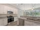Close up of modern kitchen featuring granite counters, stainless appliances, and white cabinets at 2926 River Run Way, Bradenton, FL 34208